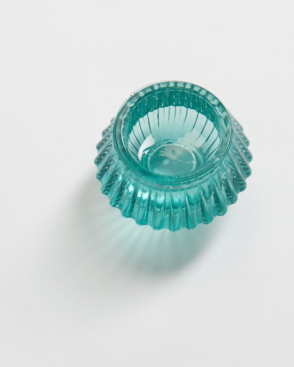 Recycled glass tealight holder, on a plain background